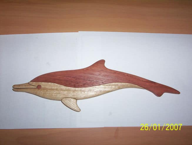 Wooden dolphin carving with intricately layered wood design.