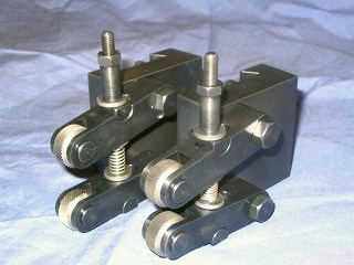 Black metal tool with threaded rods on either side, sitting on a wrinkled white cloth.