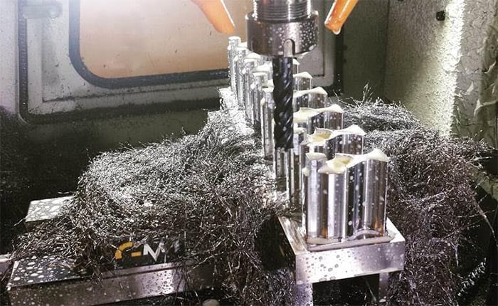 A metal fabrication or machining process, featuring a machine with tools and materials.