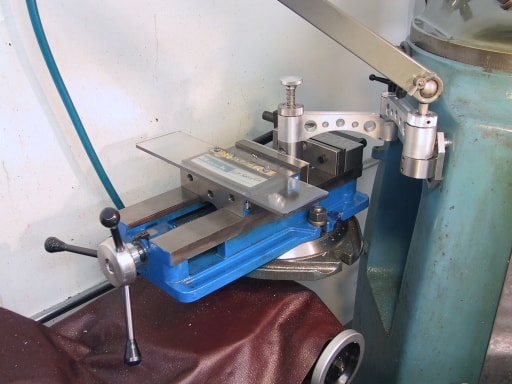 Metal vise with swing arm on machine tool.