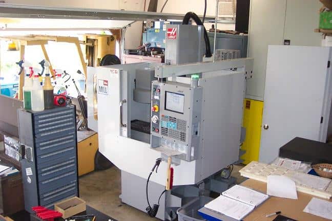 Large industrial milling or turning center machine with control panel, display screen, and tooling attachments.