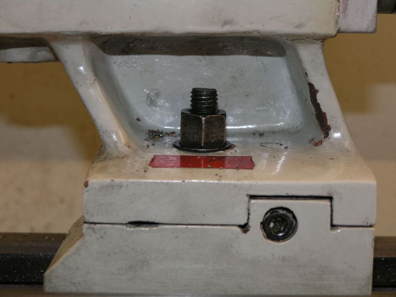 Metal machine part with central bolt on neutral background.