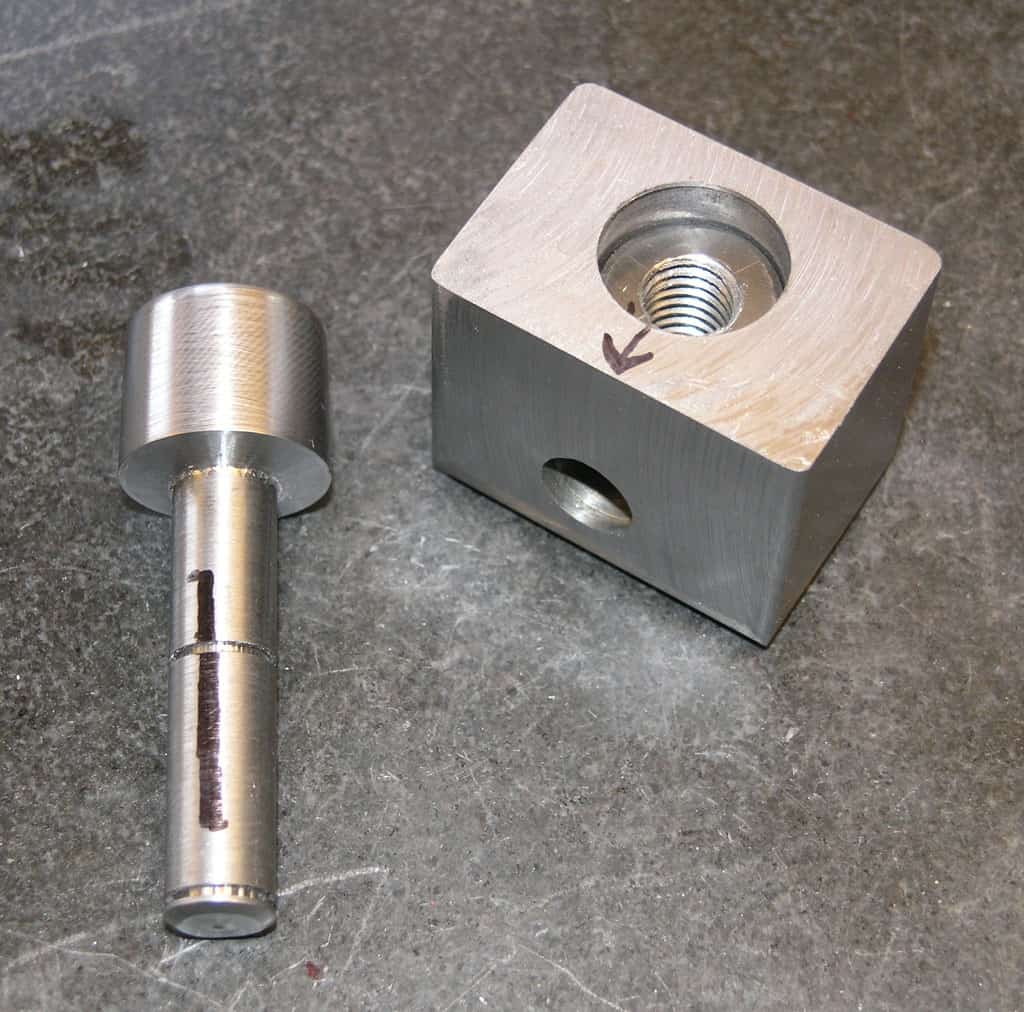 Two metal components with threaded rod and hole.