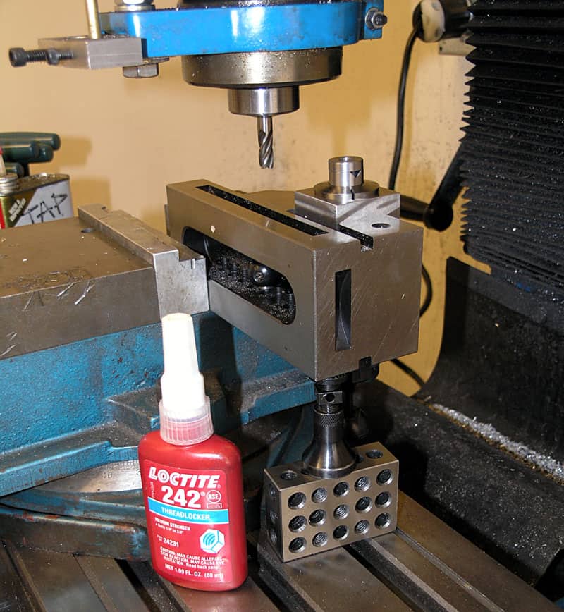 Drill press with Loctite 242 Threadlocker on beige background.