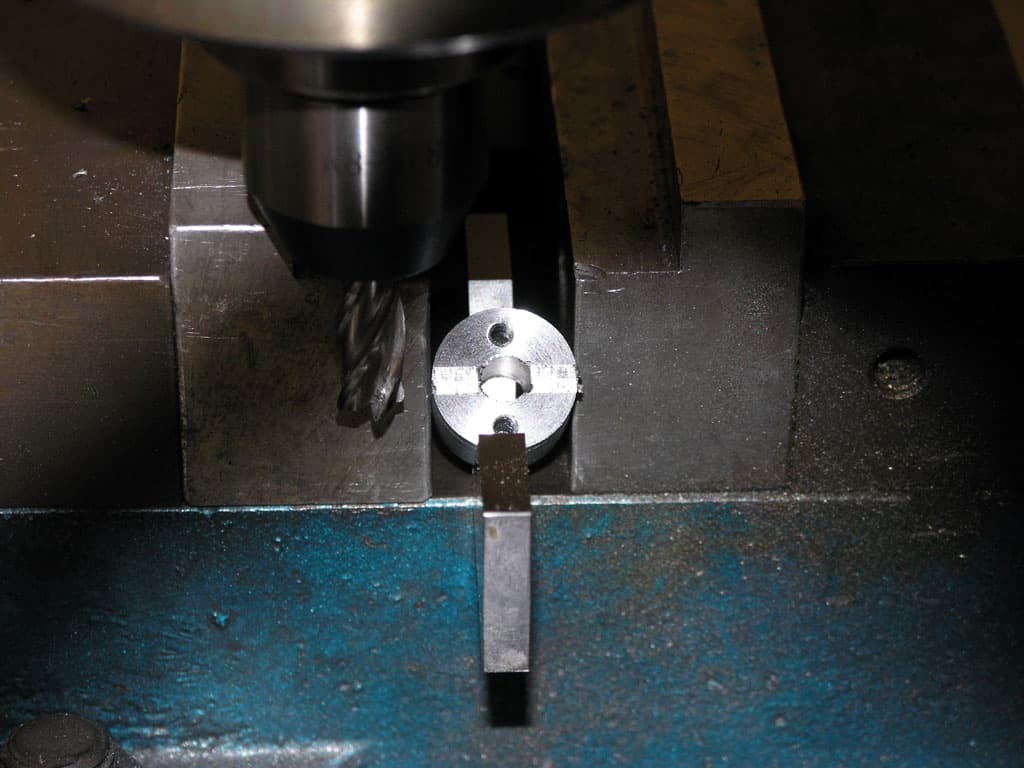 Metal workpiece being machined on milling machine.