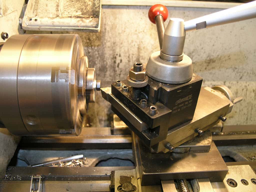 Metal lathe in machine shop or manufacturing setting.
