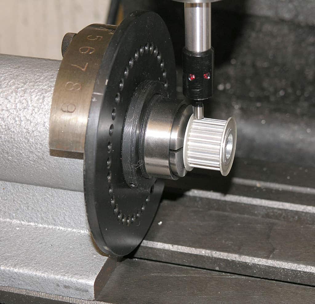 Precision measuring device attached to a workpiece with a round metal component.