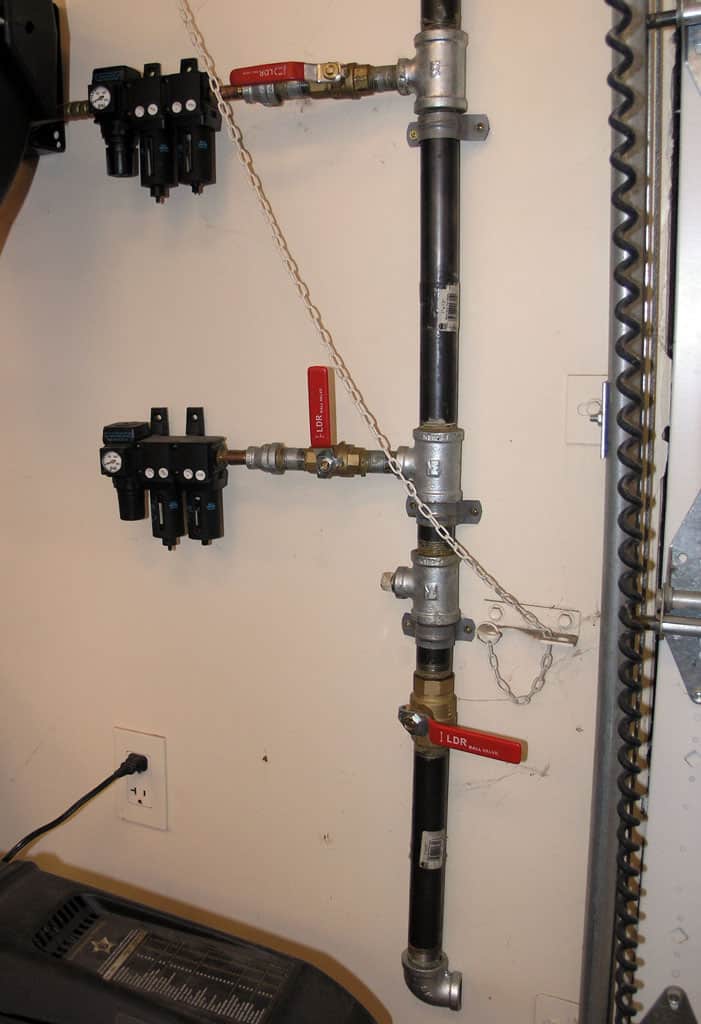Wall-mounted pipe system with valves and fittings.