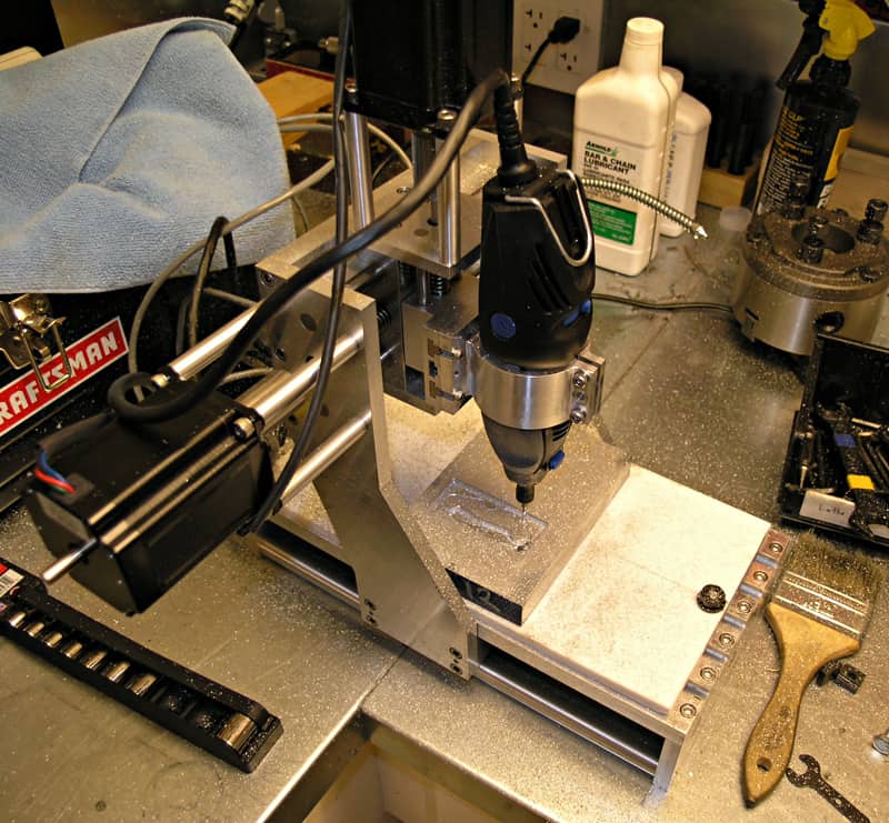 A 3-axis milling machine with tools and materials.