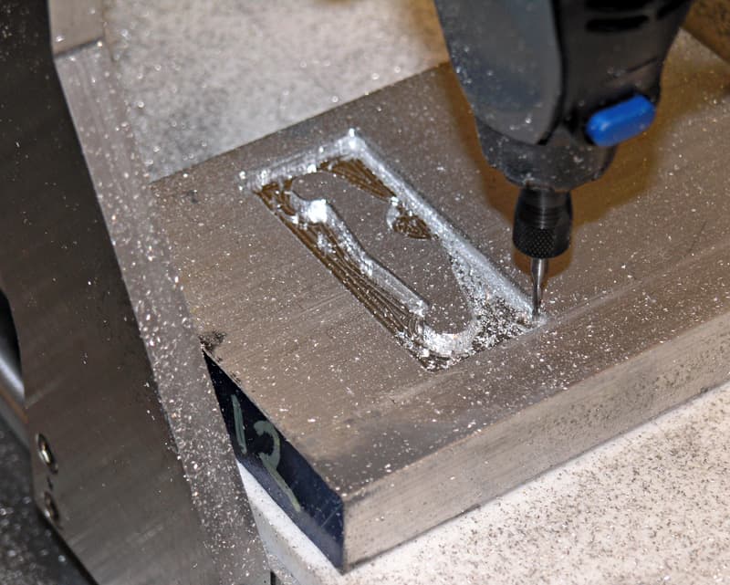 Metal cutting tool over machined surface with metal shavings.