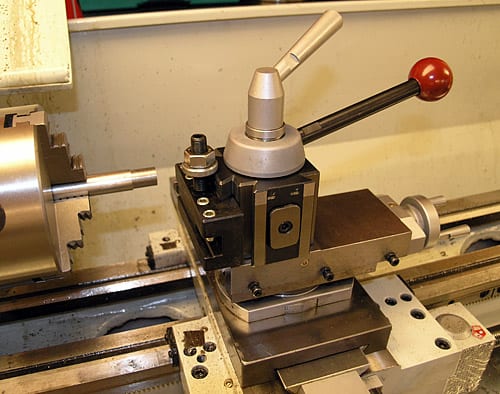 Metalworking lathe with intricate details and red handle.