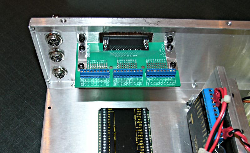 Electronic circuit board on a metal plate with various components and connected wires.