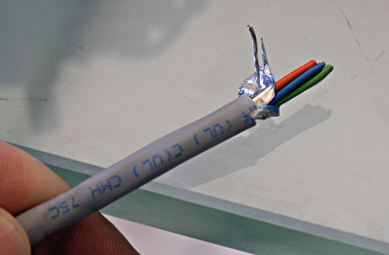 White electrical wire with blue text and four colored wires at the end (red, orange, green, blue).