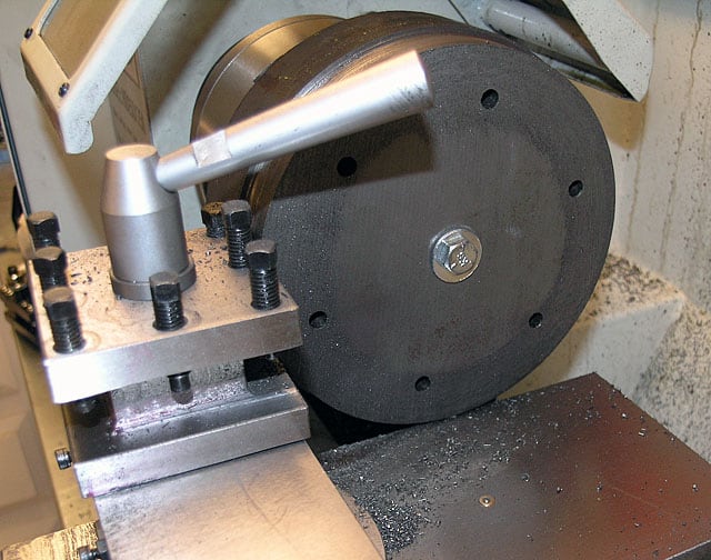 Metalworking tool with large wheel, handle, and bolts.