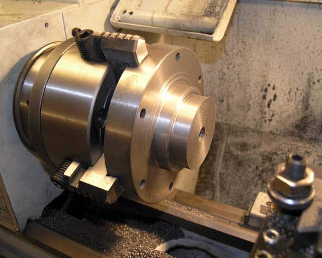 Metalworking lathe component with metallic body and attachments.