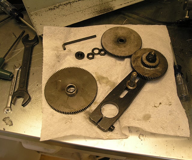 Machining tools and gears on a workbench.