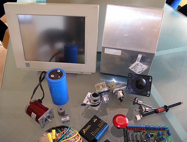 Electronic components and tools on a glass table.