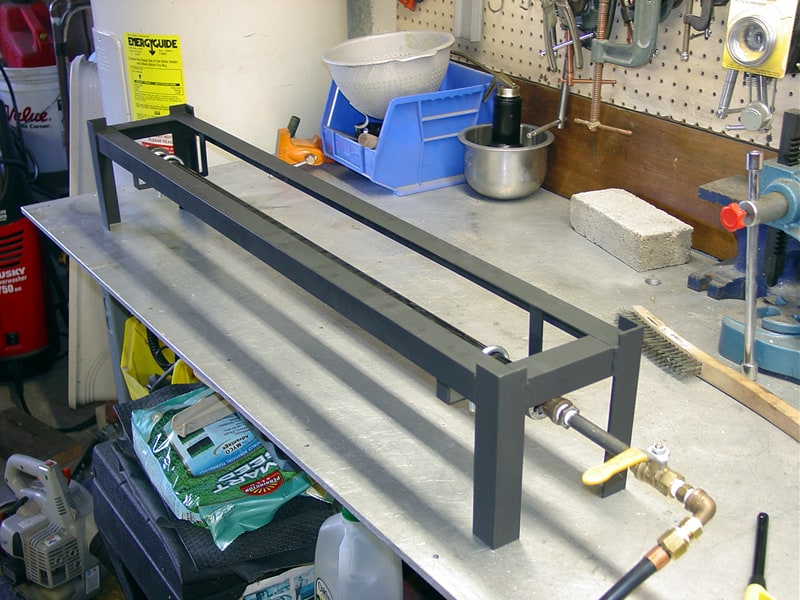 A well-organized workbench with metal frame in workshop or garage setting.