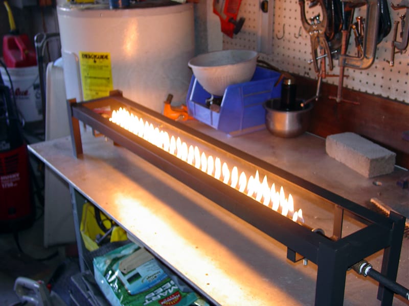 A rectangular metal firebox with flames burning inside.