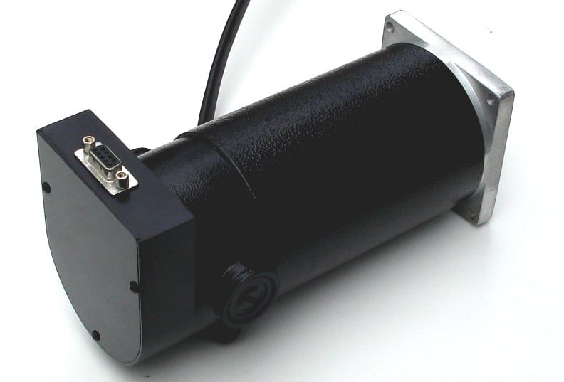 Black servo motor with silver plate on top, rectangular shape, rounded corners, white background.
