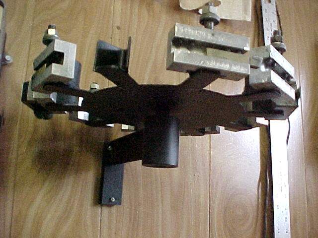Black metal tool holder with four square tools on a wooden table.