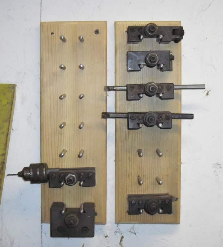 Metal tooling components arranged on wooden boards.
