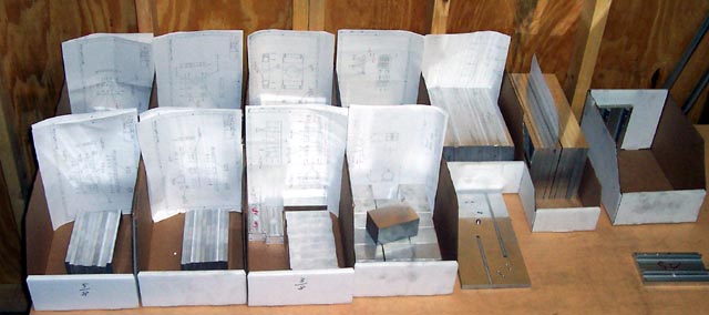 White foamcore boards with papers on top, set against a wooden background.