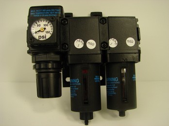 Black oiler with pressure gauge and warning labels.