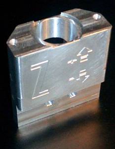 Rectangular aluminum alloy part with cylindrical hole and engravings.