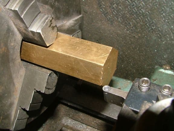 Metal part with rough edges on a machine shop workpiece.