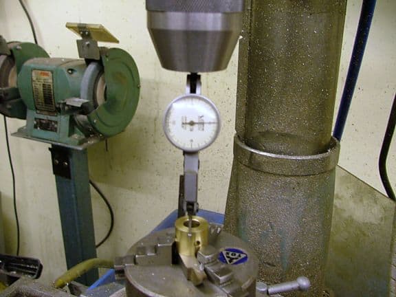 Measuring tool with a dial face and a metal cylinder.