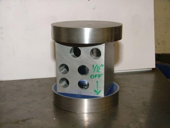 A cylindrical aluminum or stainless steel end cap with six 3/4 inch diameter holes and a flat top and bottom.