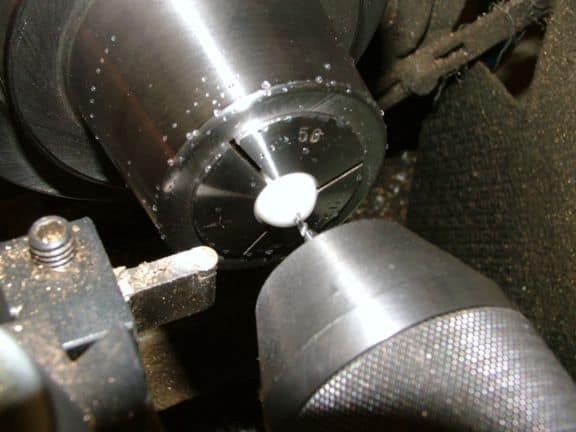 A close-up photograph of a metalworking lathe or milling machine tool on a dark background.