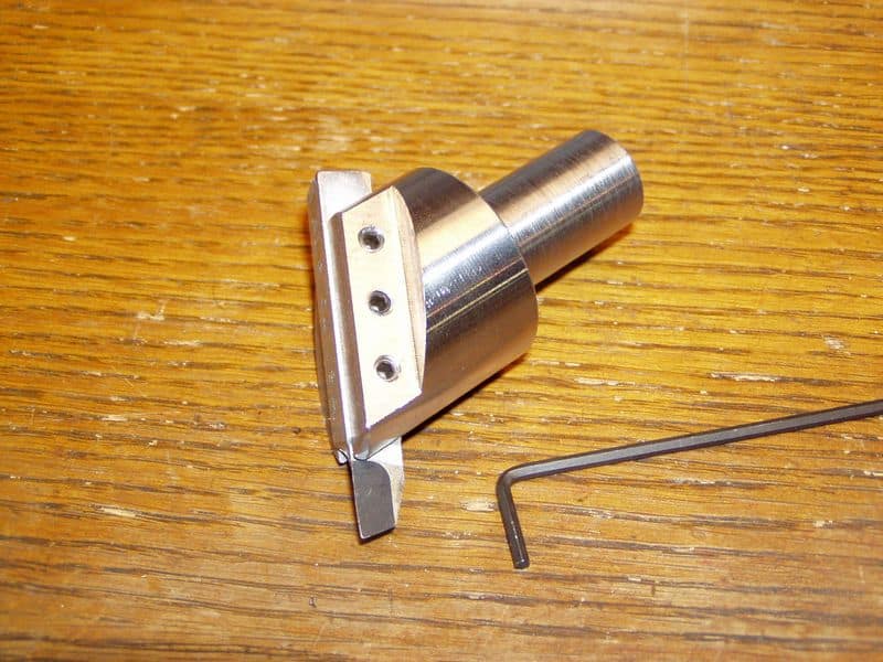Fly cutter tool with cylindrical body and flat rectangular blade.