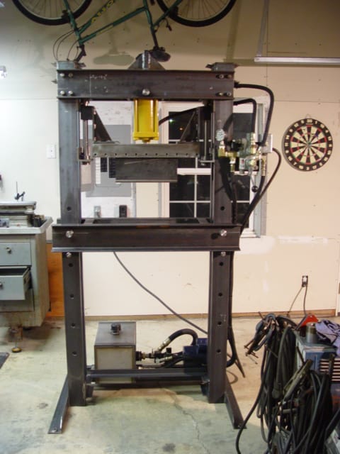Large metal workshop frame with 3D printer/CNC mill and various tools in a garage setting.