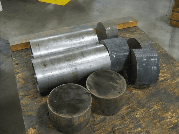 Metal cylinders of varying sizes stacked on a wooden surface.
