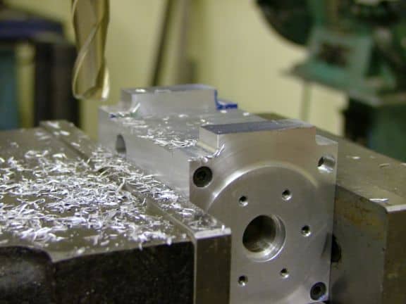 Metalworking machine spindle with milling or turning center attributes, showing rotating tool and workpiece shavings.