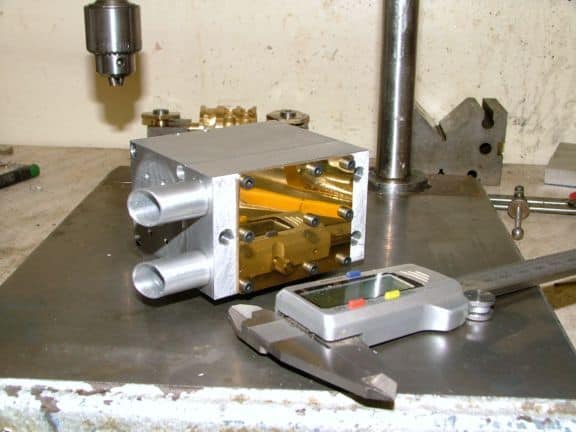 Aluminum box with brass components on a metal workbench.