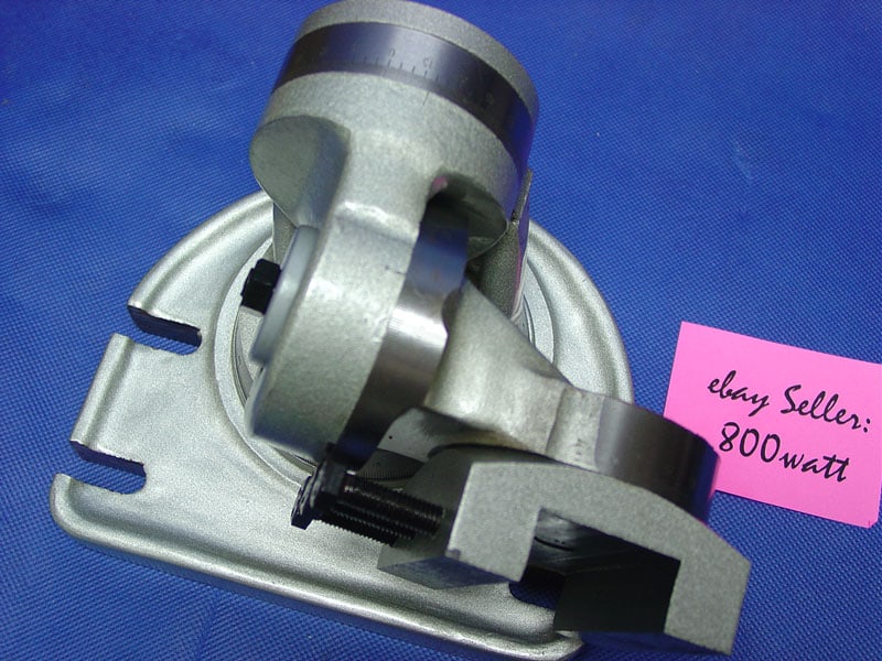 Silver metal component with a black band and cylindrical shape on a flat base.