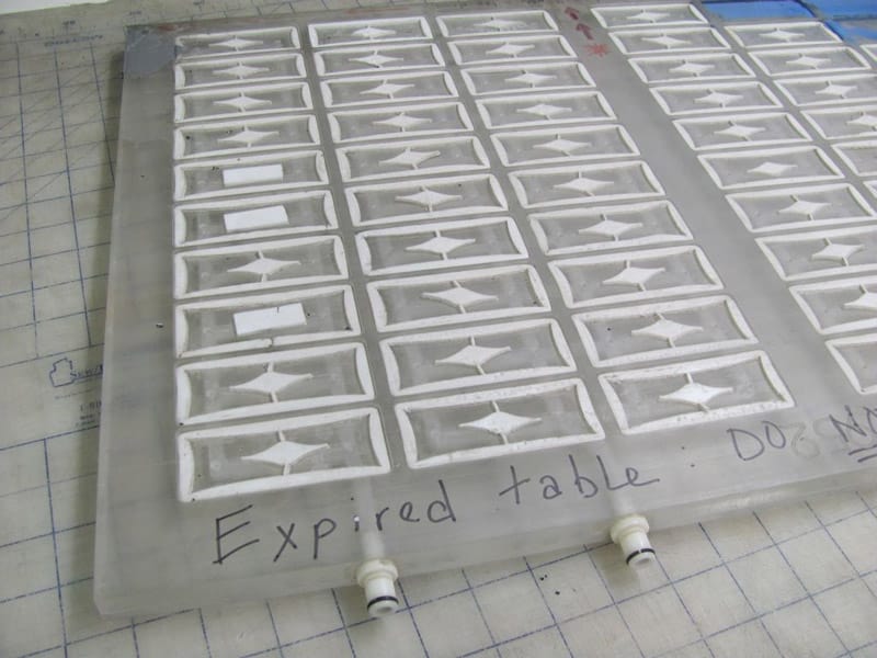 Large plastic engraving table with grid pattern and 40 small compartments featuring white arrows pointing upwards.