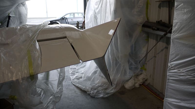 Industrial setting with a smooth, possibly plastic or metal, object featuring a flat top and bottom with slightly curved sides.