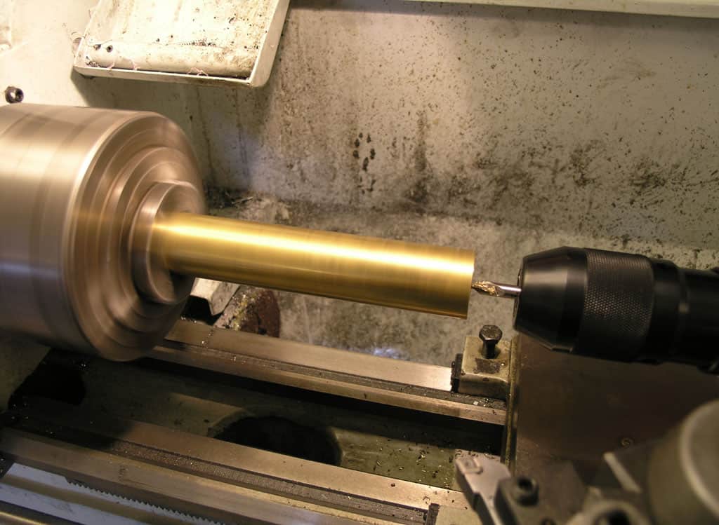 A lathe machine with a brass rod being machined on it.