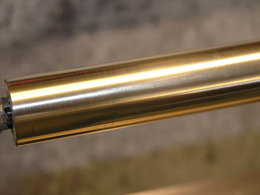 Cylindrical brass or copper object, possibly used in machining or metal fabrication.