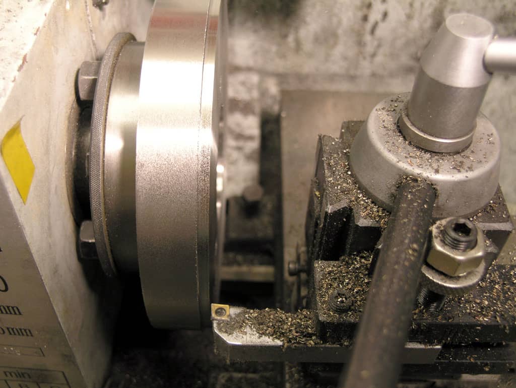 Metalworking lathe with mechanical components and machinery.