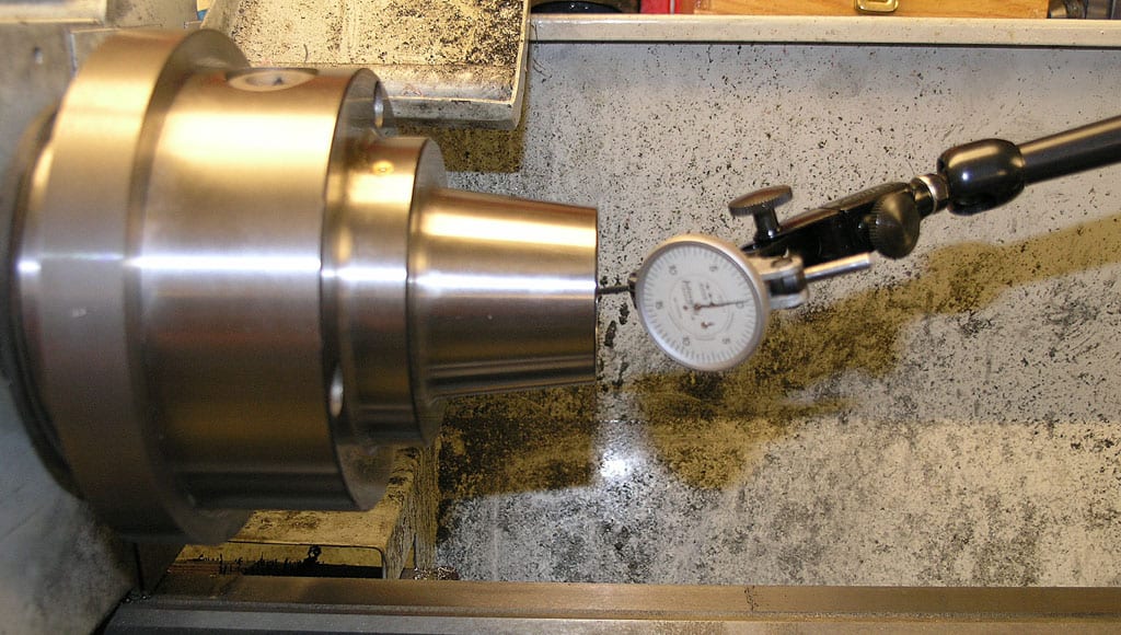 Metalworking lathe with attached dial indicator.