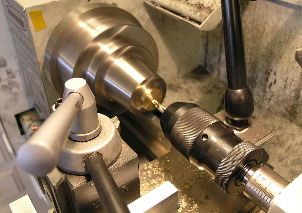 Metalworking lathe on workbench with tool post and chuck.