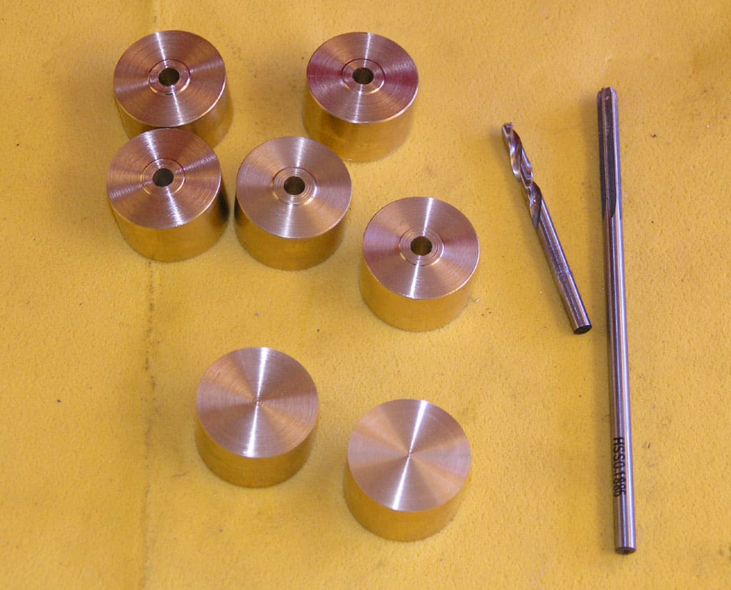 Precision cutting tools and components on a yellow workbench.