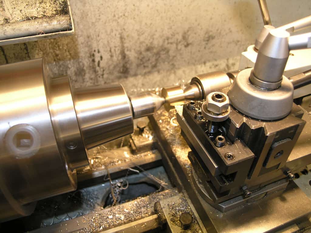 Metalworking lathe with adjustable cutting tool and spindle.