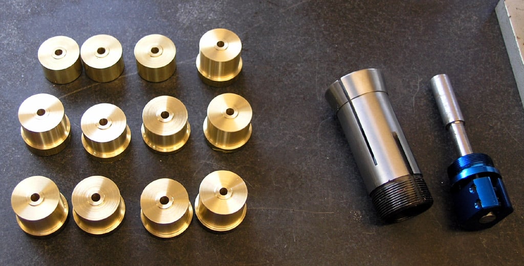 Brass and steel machined components with cylindrical and threaded shapes.