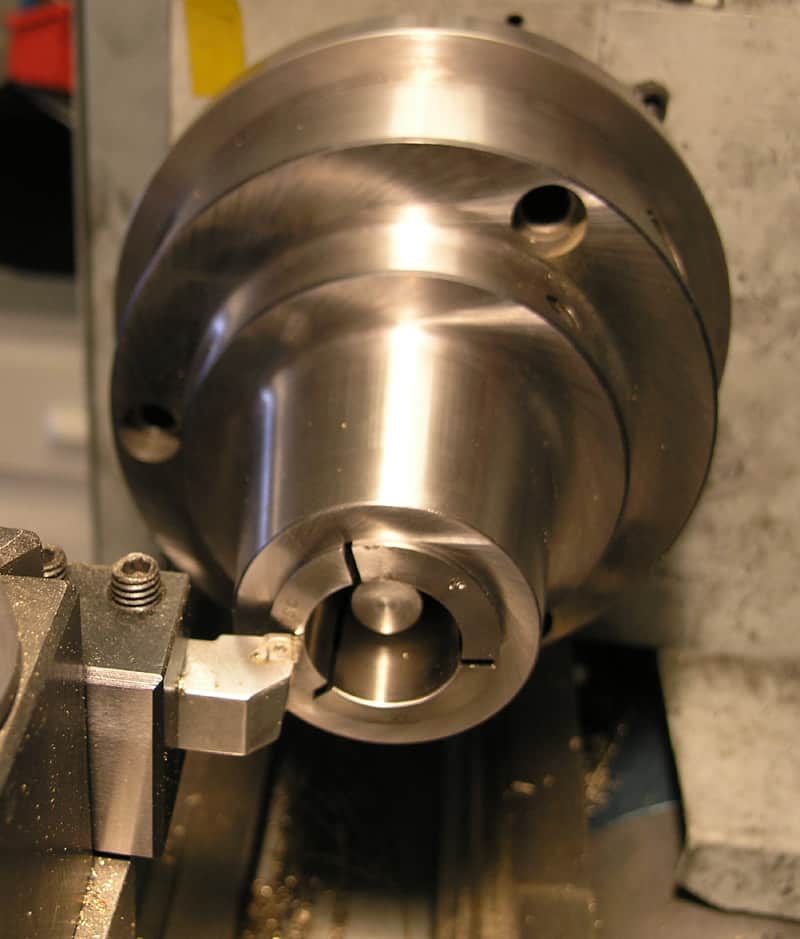 Large cylindrical metal component with series of holes.